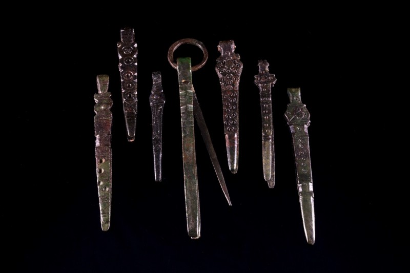 Lot of 7 Roman Bronze surgical or medical tweezers, decorated and with suspensio...