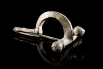 Roman Bronze Crossbow Fibula, 3rd-4th century AD (7.5cm). Heavy brooch with three knobs, long foot decorated with pellet-in-circle designs. Intact wit...