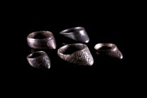 Lot of 5 Byzantine Bronze Archer's Rings with convex triangular extension decorated with incised scrolled designs and central ovoid motif. c. 10th-14t...