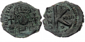 Justinian I AE 20 Nummi. Theoupolis (Antioch)
helmeted and cuirassed bust facing, holding globus cruciger and shield; cross in right field.
Rev: Large...