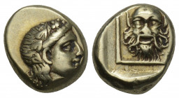Greek
Lesbos, Mytilene EL Hecte. Circa 377-326 BC. 2.53gr. 11.3mm.
 Head of Dionysos facing right, wearing ivy-wreath / Mask of Silenos facing in thin...