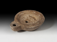 ROMA. Imperio Romano. Lucerna (II d.C.). Cerámica. Pasta grisácea, un agujero de llenado, piquera circular y disco central decorado con máscara teatra...