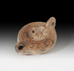 ROMA. Imperio Romano. Lucerna (225-275 d.C.). Cerámica. Pasta anaranjada, dos agujeros de llenado, piquera circular y disco central decorado con motiv...