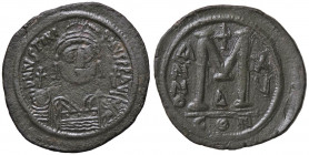 BIZANTINE - Giustiniano I (527-565) - Follis - Busto elmato e corazzato di fronte con globo crucigero /R Lettera M sormontata da croce accostata da AN...