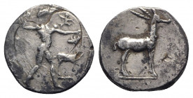 Bruttium, Kaulonia, c. 475-425 BC. AR Stater (20mm, 8.06g, 5h). Nude Apollo walking r., holding branch, holding small running daimon on outstretched a...