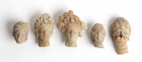 Collection of five Greek terracotta small heads of Aphrodite; two cracked but restorables; ca. 4th - 3rd centuries BC; maximun height cm 4,2