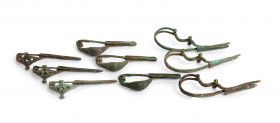 Collection of nine Greek - Italic - Etruscan - Celtic bronze brooches (fibulae) of various typologies (navicella, dragon), all with intact pins; ca. 7...
