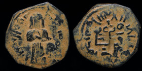 UMAYYAD: 'Abd al-Malik ibn Marwan, AE fals, Standing caliph type, issued c. 690s. Tanukh, 2.90g, 21mm. 
Obv: Caliph standing facing, holding on sheath...