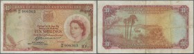 Rhodesia & Nyasaland: 10 Shillings 1961 P. 20, used with stronger folds, stain in paper, one minor hole, condition: F- to F.