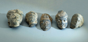 A collection of five rare Gandharan stone heads from the Indus Valley, ca. 3rd - 4th Century A.D. They are 1-1/4 to 1-1/2 inches high and are carved f...