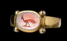 A roman garnet intaglio set in a postclassical gold ring. Peacock.