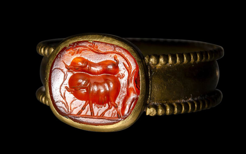 A roman carnelian intaglio set in a Postclassical gold ring. Two pigs. 

2nd c...