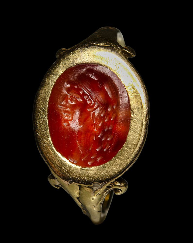 A roman carnelian intaglio mounted in a postclassical gold ring. Herakles portra...