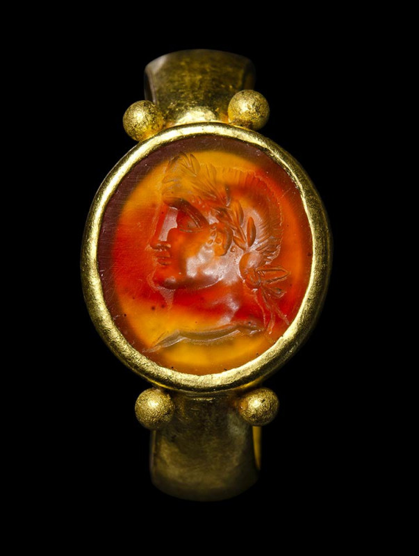 A north-european roman gold ring set with a carnelian intaglio. Emperor portrait...
