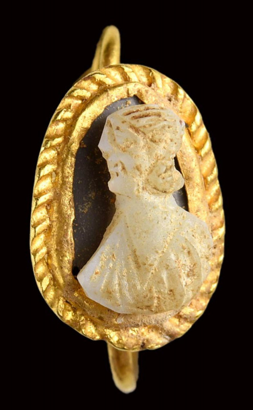 A roman two-layered onyx cameo set in an antique gold earring. 

3rd century A...