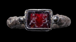 A silver late roman signet ring with a garnet intaglio. Warriors.