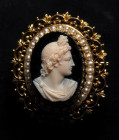 A neoclassical onyx cameo set in a gold brooch with pearls. Bust of Apollo.