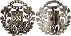 Pin devocional con anagrama de María superado de cruz. Debajo flor. Plateado. 4,72 g. 28x28 mm. EBC.