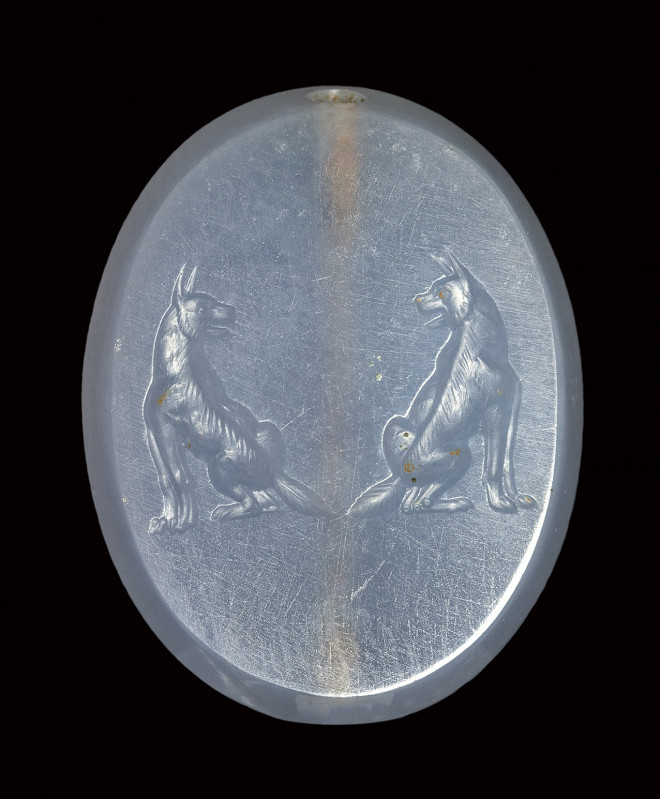 A fine late classical greek blue chalcedony scaraboid seal. Two molossian dogs....