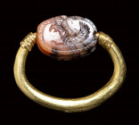 A Greek archaic agate scarab scaraboid seal set in a swivel gold ring. Griffin.