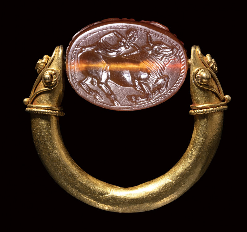 An etruscan carnelian engraved scarab set in a gold swivel ring. Europa with Zeu...