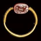 An etruscan carnelian scarab intaglio set in a  gold swivel ring. Bull.