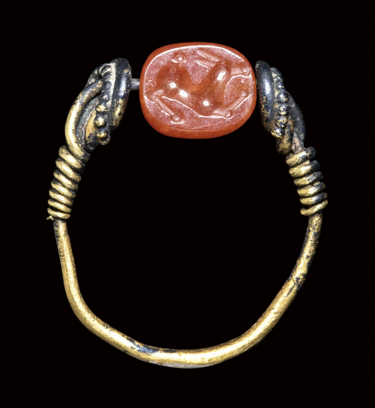 A small etruscan carnelian intaglio mounted in a gold ring. Antelope. 

3rd ce...