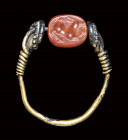 A small etruscan carnelian intaglio mounted in a gold ring. Antelope.