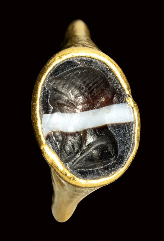 A late hellenistic gold ring set with a banded agate intaglio. Bust of Herm.

...