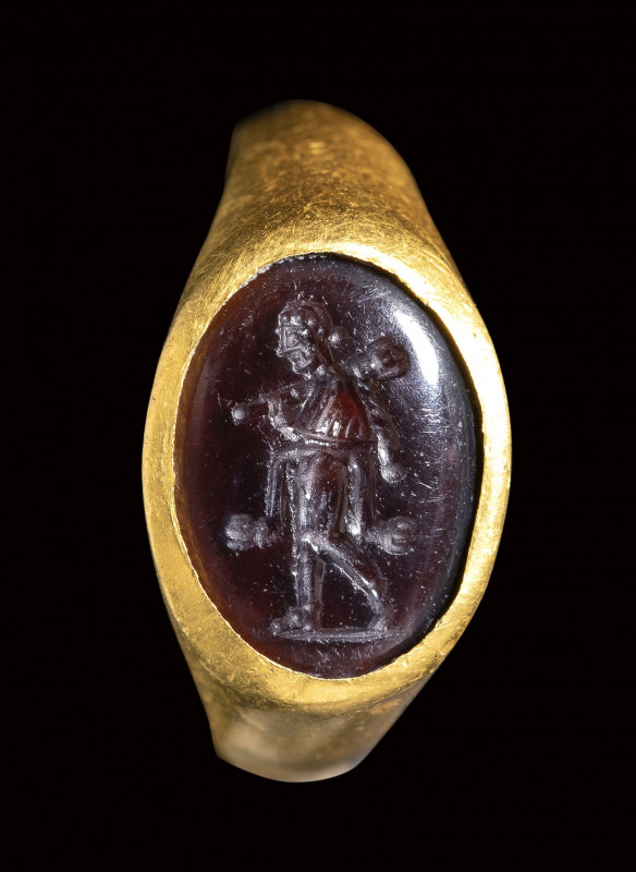 A late italic garnet intaglio set in a gold ring. Omphale. 

2nd - 1st century...