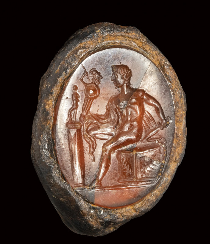 A fine roman carnelian intaglio set in a fragmentary iron ring. Diomedes with Pa...