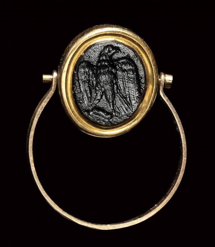 A roman dark glass paste intaglio set in a gold swivel ring. Eagle.

1st - 3rd...