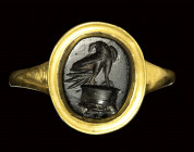 A roman late republican obsidian intaglio mounted on a modern gold ring. Eagle on altar.