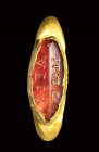 A late roman gold signet ring set with a carnelian intaglio. Greek letters.