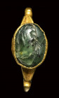 A roman green chalcedony intaglio mounted in a gold ring. Pastoral scene.