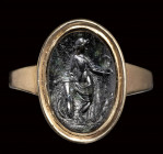 A roman dark green chalcedony intaglio set in a gold ring. Venus Victrix.