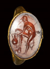 A roman carnelian intaglio set in a gold ring. Heraclides attempting a draw.