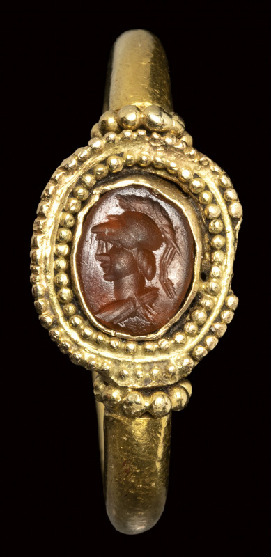 A roman carnelian intaglio set in an ancient gold ring. Bust of Athena. 

3rd ...