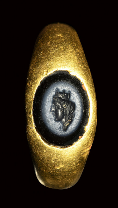 A roman gold ring set with a nicolo intaglio. Portrait of Tyche of Antioch. 

...