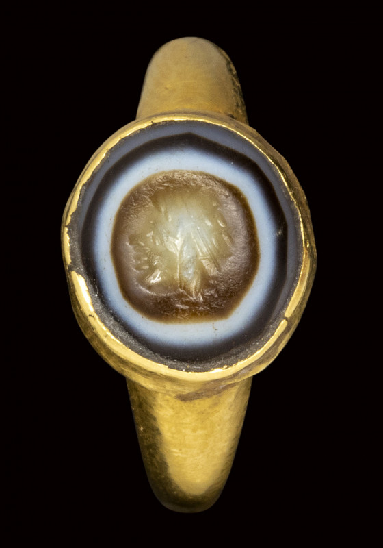 A roman agate intaglio set in an ancient gold ring. Mask.

2nd - 3rd century A...