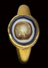 A roman agate intaglio set in an ancient gold ring. Mask.