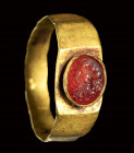 A roman carnelian intaglio set in a gold ring. Head of a Silenus.