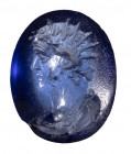 A roman blue glass intaglio. Portrait of Helios.