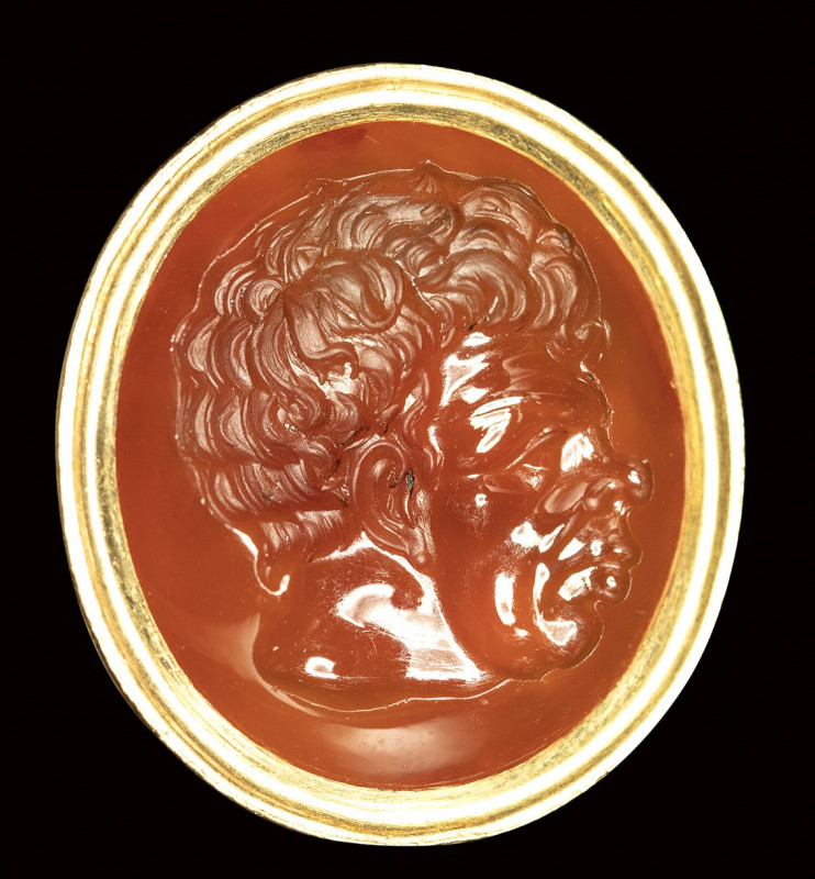 A carnelian intaglio set in a gold fob seal. Male grotesque portrait.

Mid 18t...