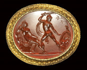 A fine neoclassical  carnelian intaglio signed Gnaios, set in a gold brooch. Perseus cutting the head of Medusa.