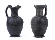 COUPLE OF ETRUSCAN BUCCHERO OINOCHOAI
ca. 550 BC
height cm 30 and 31

Molded in bucchero "pesante", these two oinochoai have ovoid body, trefoil mouth...