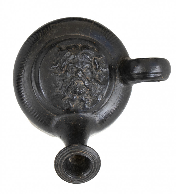 APULIAN BLACK-GLAZED GUTTUS
ca. 300 BC
height cm 12

With a fronting head of a b...