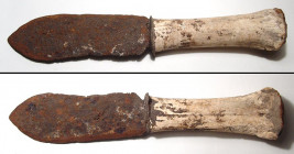 A Medieval iron knife, ca. 10th - 14th Century A.D. , the wide blade sharpened and set into a bone handle with remains of iron guard and pommel. Well-...