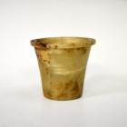 ANTIGUO EGIPTO. Vaso con cuerpo troncocónico y borde exvasado. Imperio Medio (ca. 1991-1786 a. C). Alabastro. Altura 6 cm.