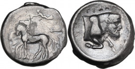 Sicily. Gela. AR Tetradrachm, c. 425-420 BC. Obv. Charioteer, holding kentron and reins, driving slow quadriga left; above, Nike flying left, crowning...